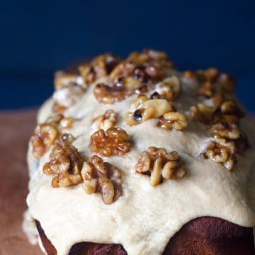Close-up of a coffee and walnut loaf cake on a wooden board.