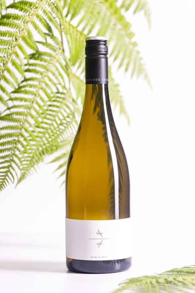 A bottle of Catalina Sauvignon Blanc from Marlborough in front of ferns.