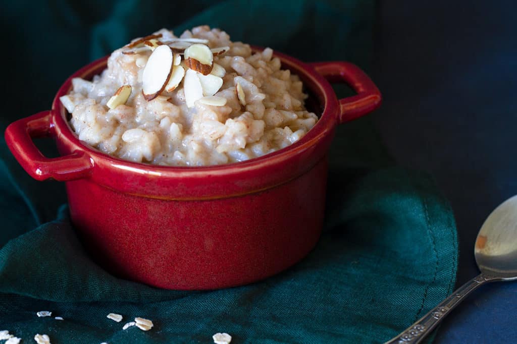 A red bowl creamy rice pudding with a dark background.