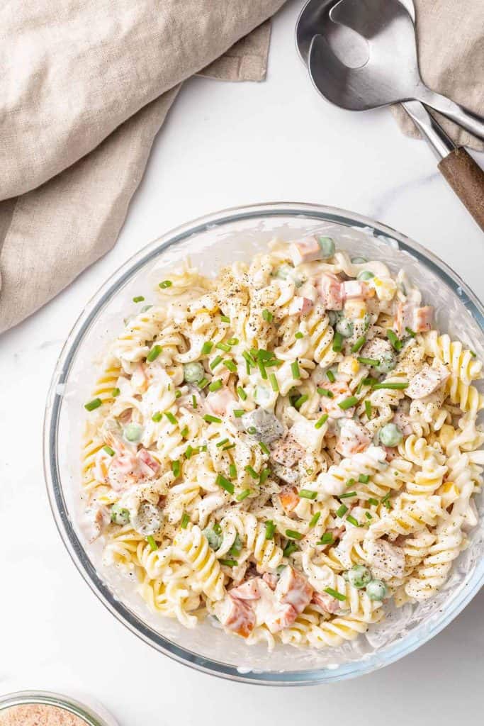 Creamy pasta salad in a large glass bowl.