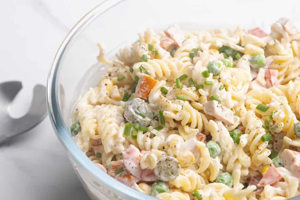 Creamy pasta salad in a large glass bowl.