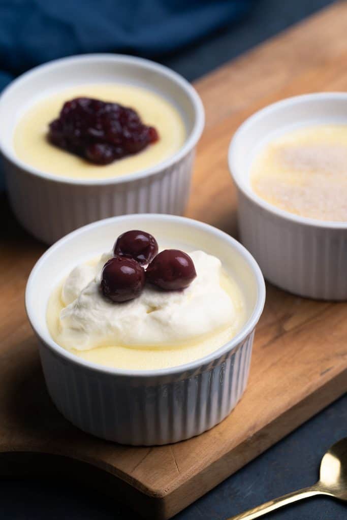 Three ramekins with creamy semolina pudding and different toppings.