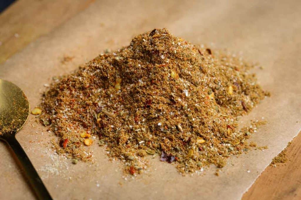 A pile of homemade burrito spice mix on a wooden board.