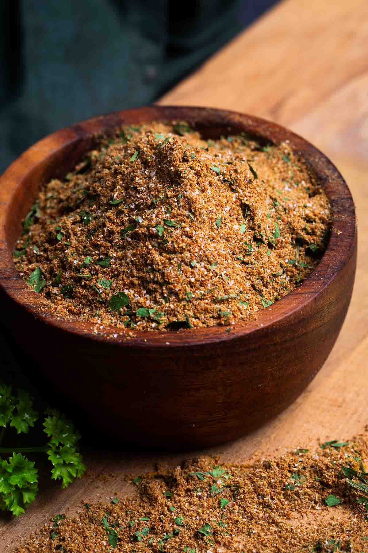 Chermoula spice blend in a wooden bowl which sits on a wooden board.