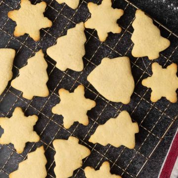 Traditional German butter cookies on a wire rack. Dark background.