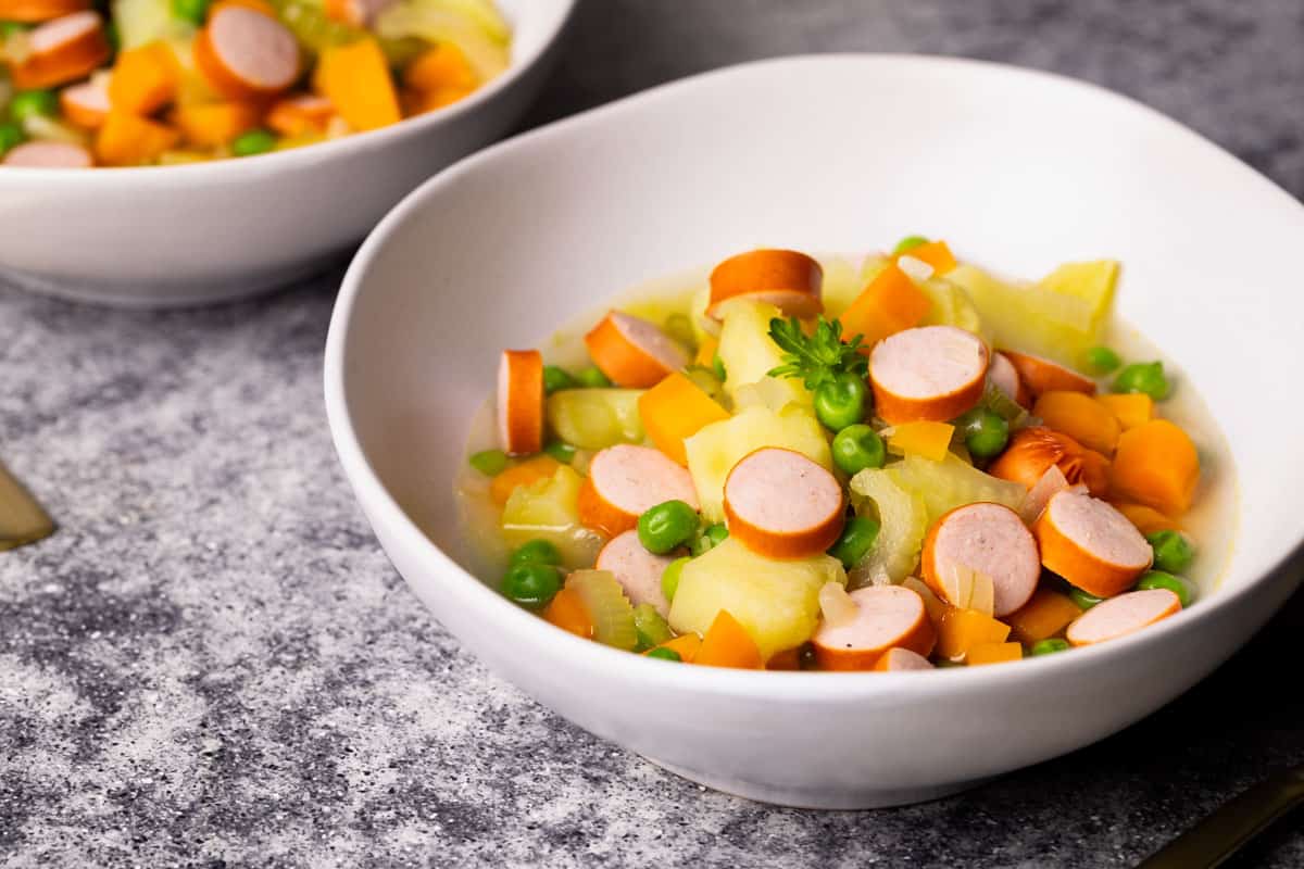 German stew with Franks in white soup bowls.