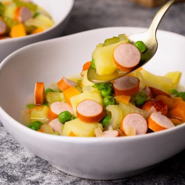 German stew with Franks in white soup bowls.