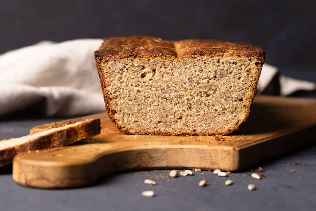 A seeded rye sandwich bread on a wooden board.