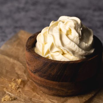 A wooden bowl filled with brown sugar whipped cream.