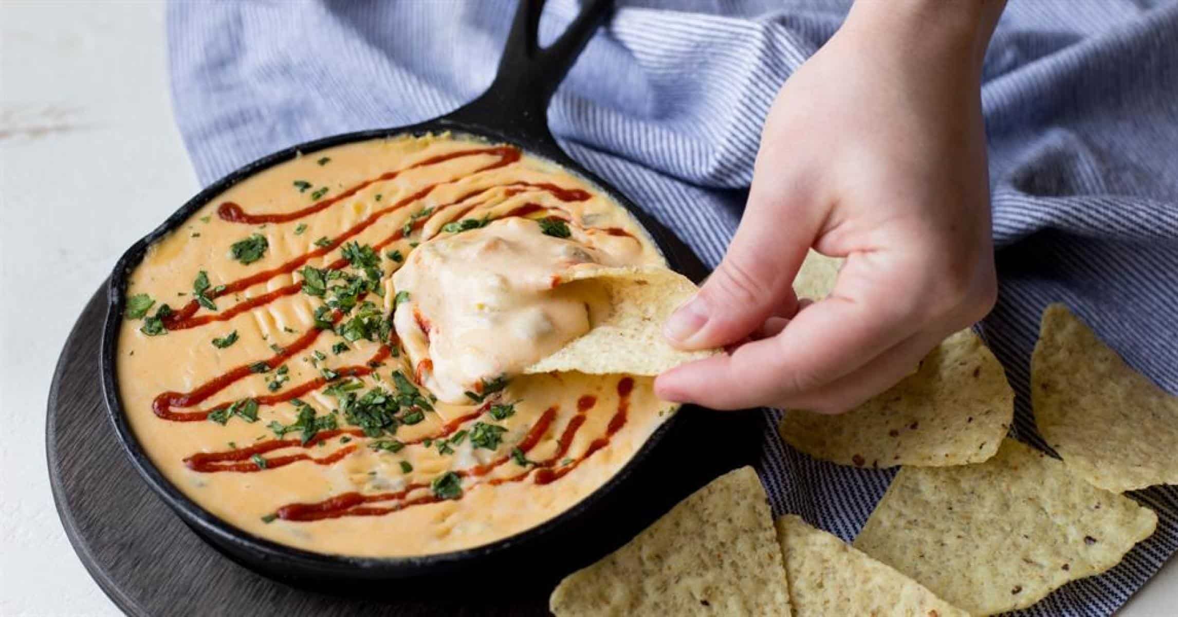Cheese dip prepared in a cast iron skillet served as a side.