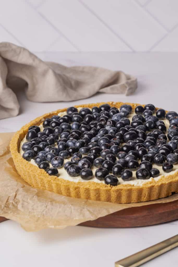 Blueberry cheesecake tart on a wooden board.