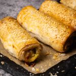 Puff pastry hot dogs on baking paper.