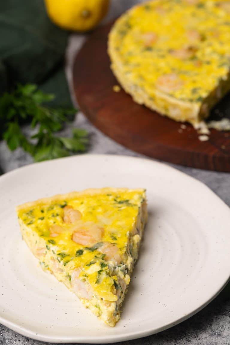 Shrimp quiche slice on a white plate.