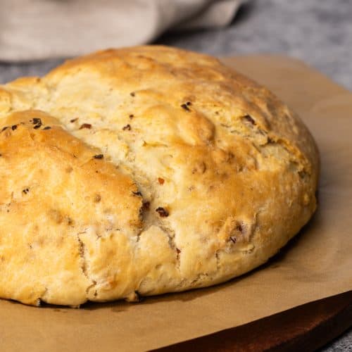 Lard bread on parchment paper next to a linen tea towel.