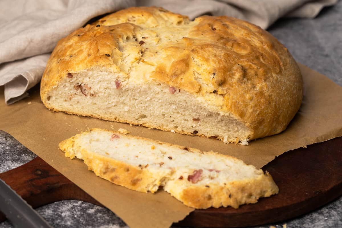 Lard bread on parchment paper next to a linen tea towel.