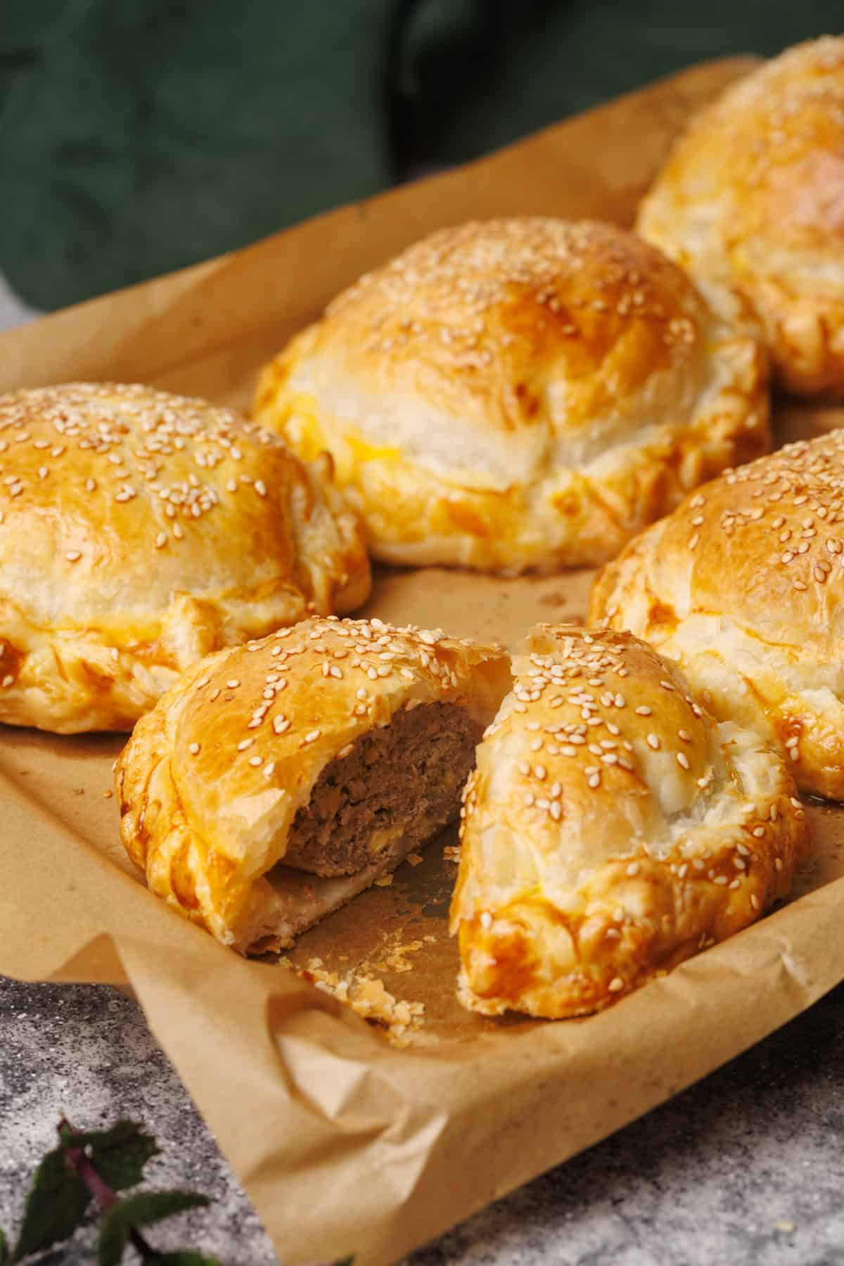 Beef wellington on a baking tray, one is cut open.