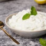 Cucumber yogurt mint sauce in a small bowl with a golden spoon.
