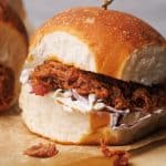Pulled lamb burgers on a wooden board.