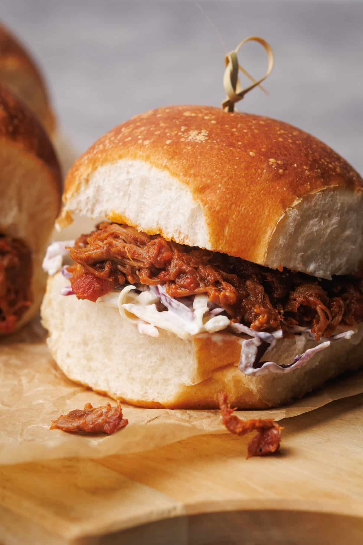 Pulled lamb burgers on a wooden board.