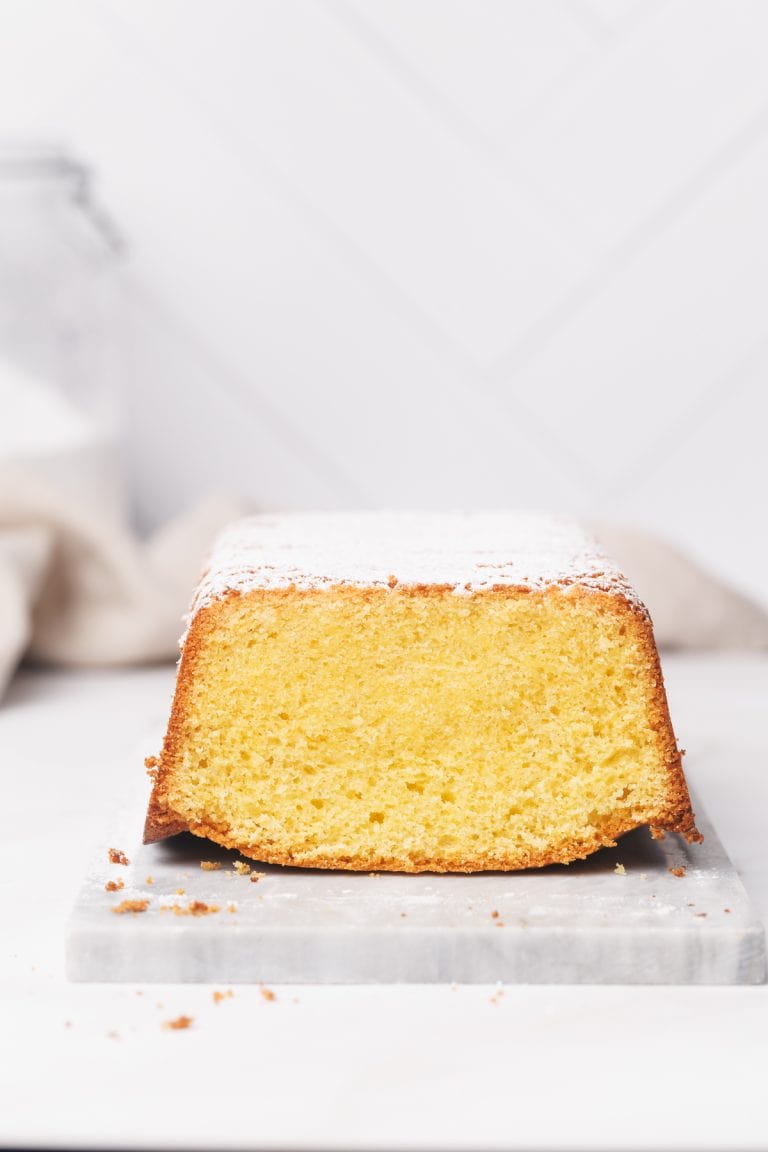 Vanilla pound cake on a marble tray, white background.