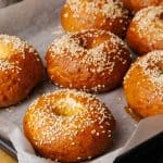 Pretzel bagels on a baking tray.
