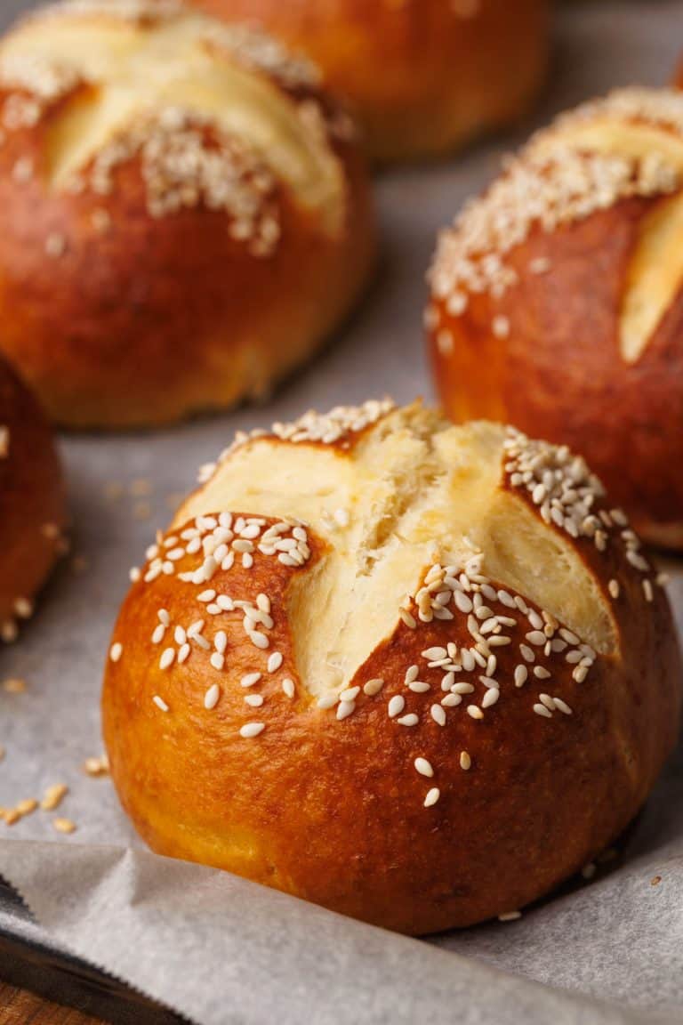 Pretzel buns on a baking tray just after being baked.