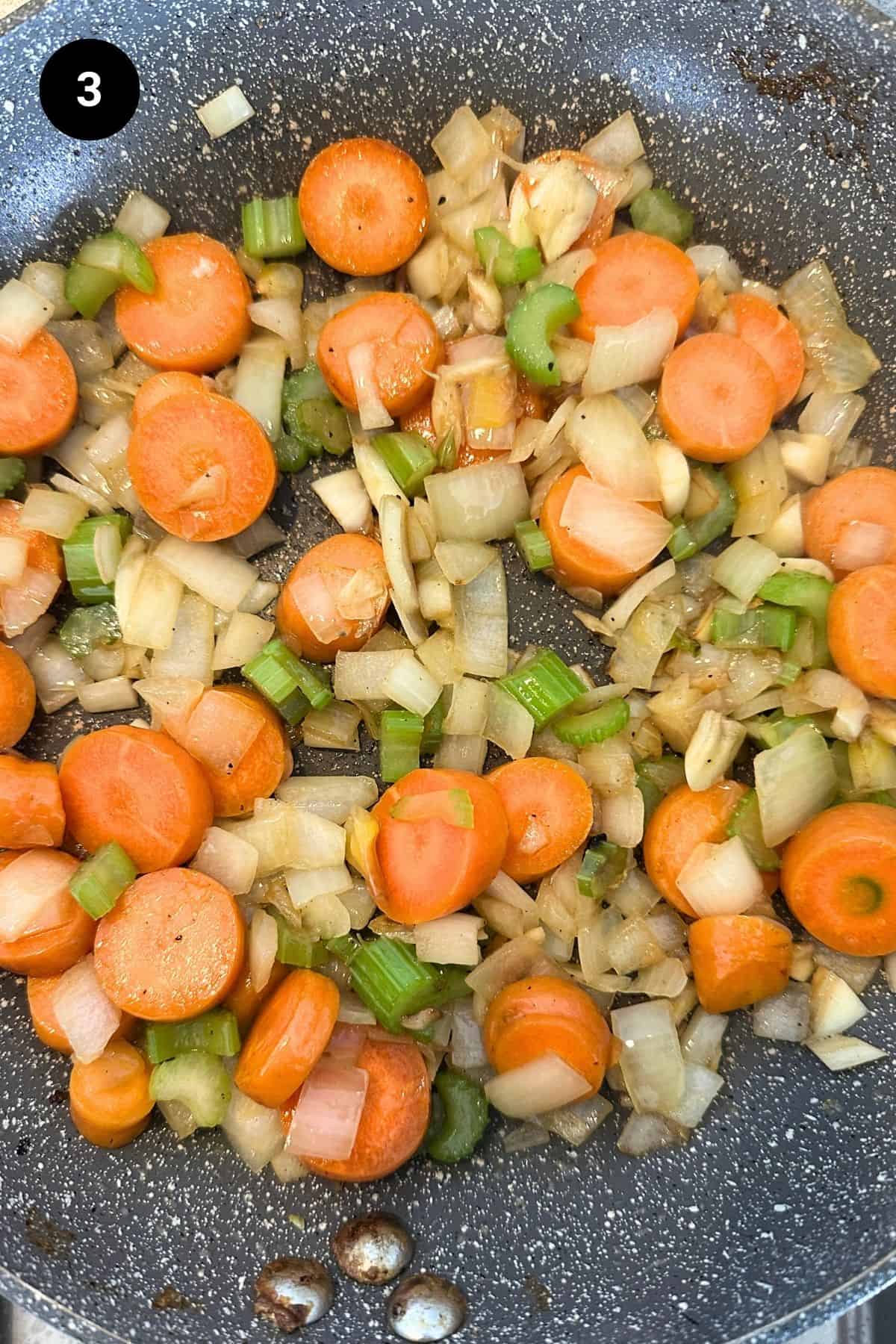Vegetables being sautéed in a pan.