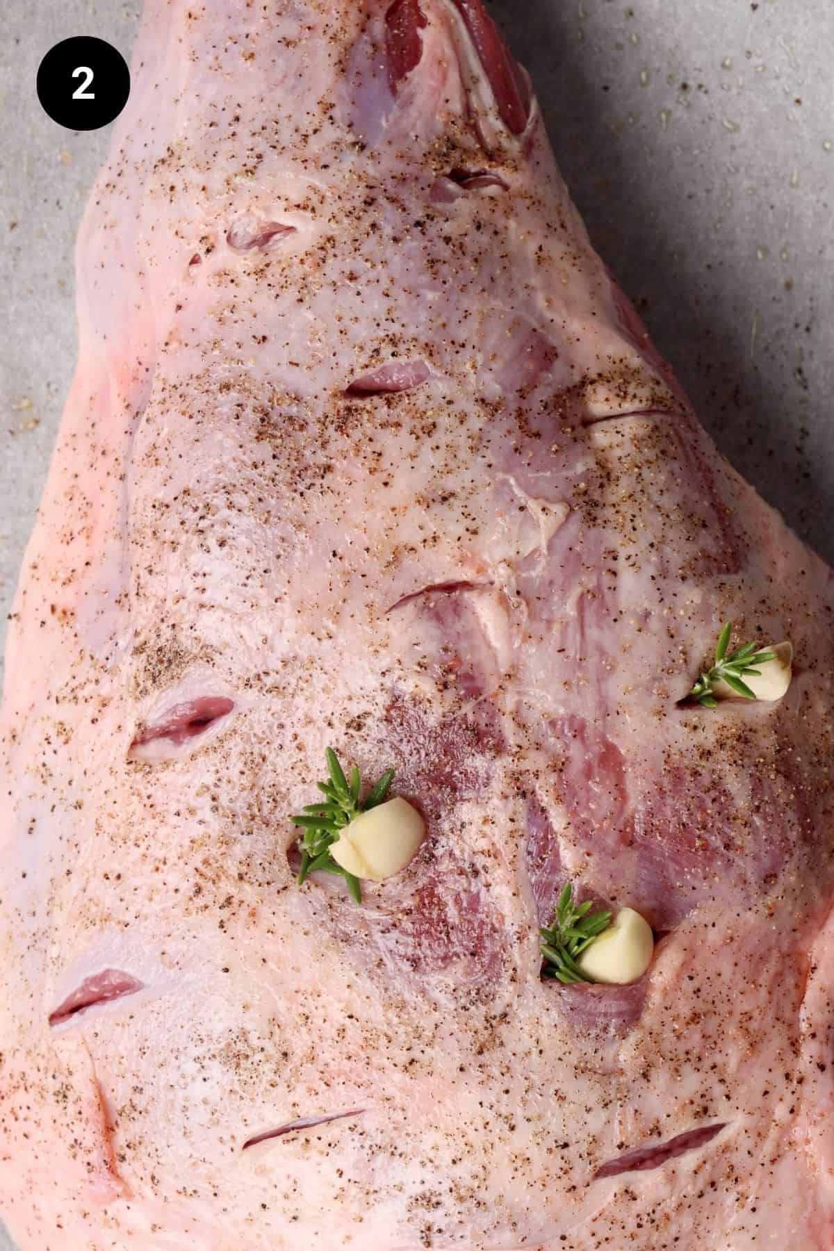Garlic and rosemary is placed in holes.