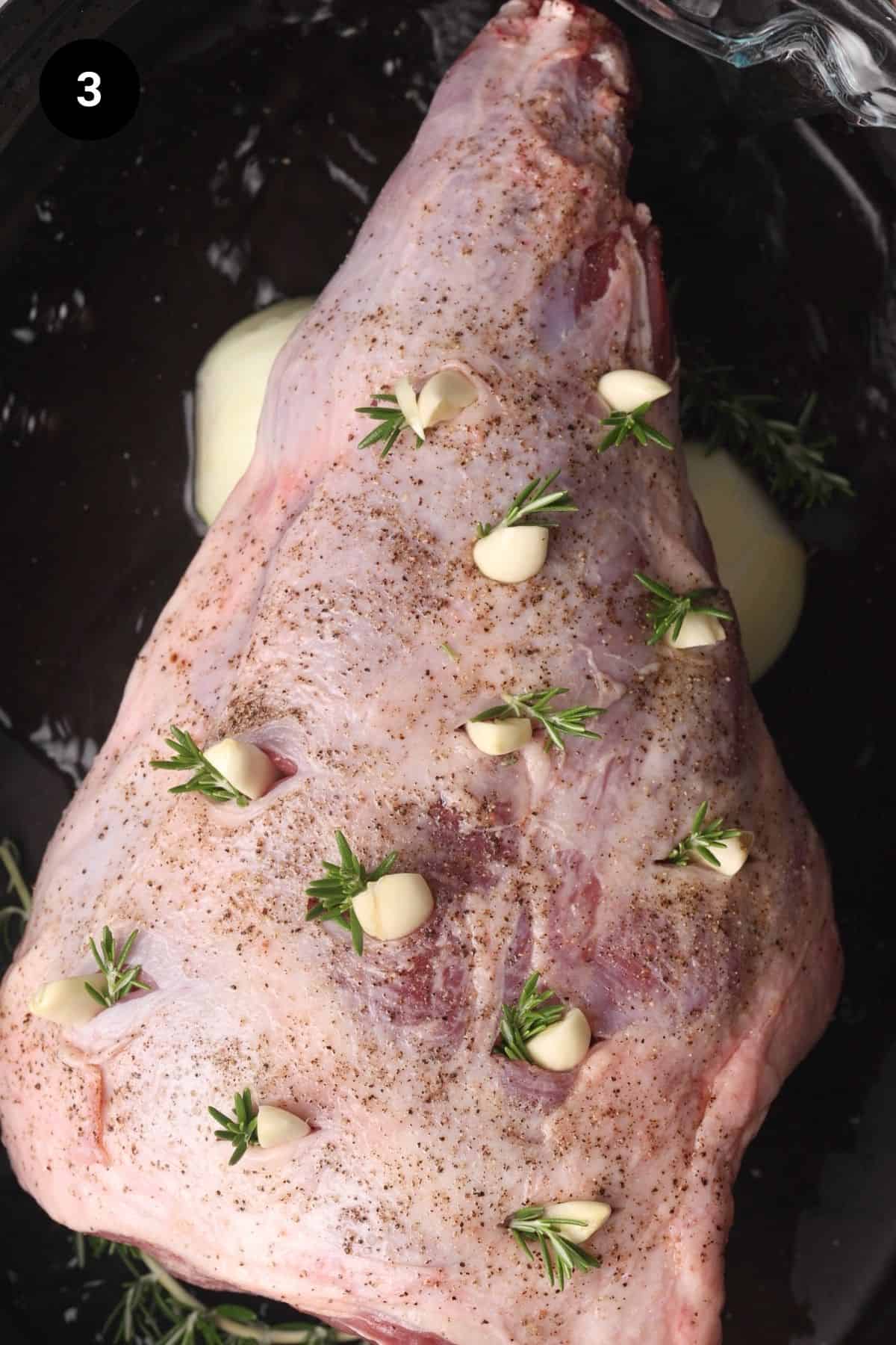 Leg of lamb is placed onto garlic and onion trivet.