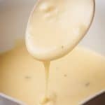 Garlic sauce being drizzled from a spoon.