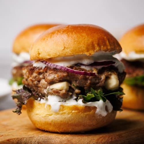 A lamb slider on a wooden board.
