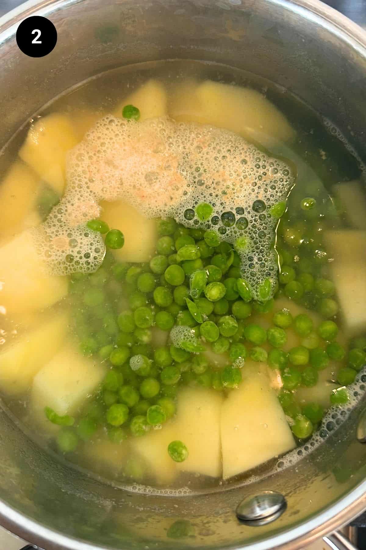 Peas and potatoes in a large pot in water.