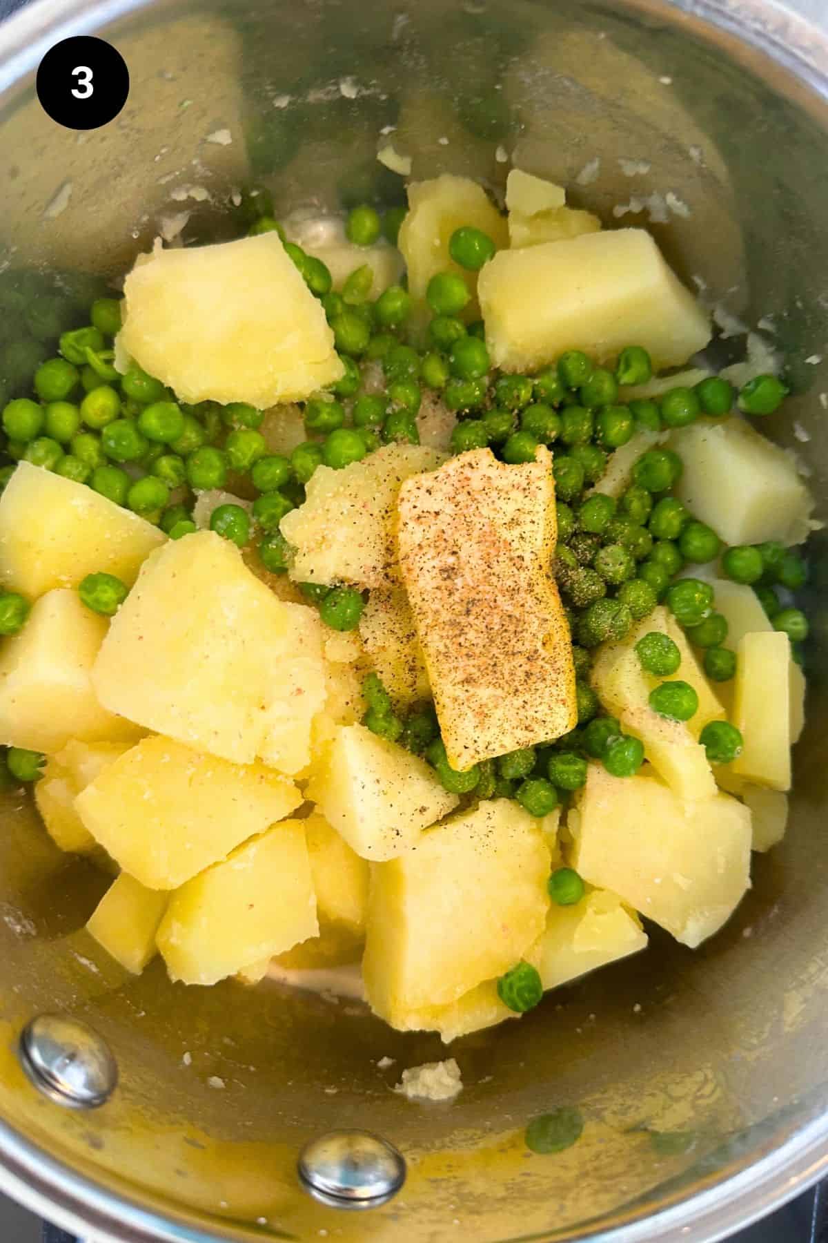 Butter and milk added to cooked potatoes and peas.