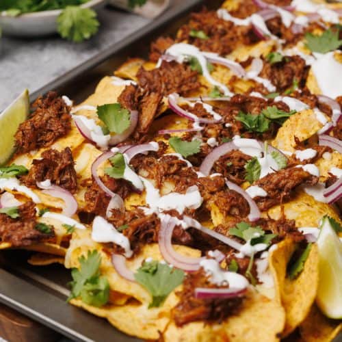 Birria nachos ready to serve on a baking tray.