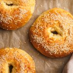 Cottage cheese bagels on a lined baking sheet.