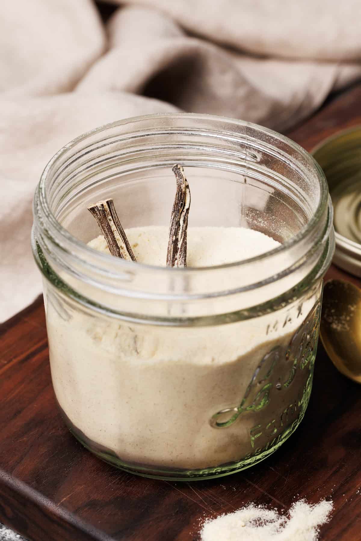 Vanilla powdered coffee creamer in a mason jar on a wooden board.