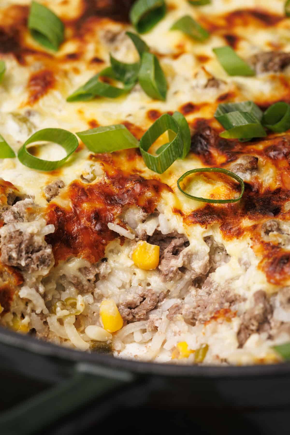 Casserole dish on a wooden board, one serving taken out of it.