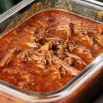 Beef barbacoa in a glass container.