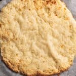 Cottage cheese pizza crust on parchment paper.