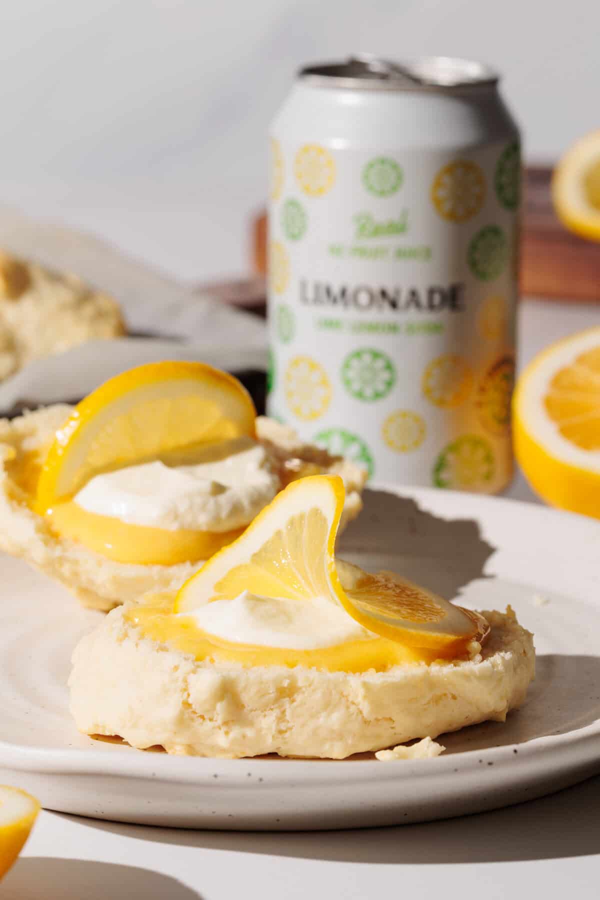 Lemonade scone with lemon curd and cream on a white plate.