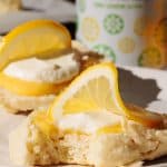 Lemonade scone with lemon curd and cream on a white plate.