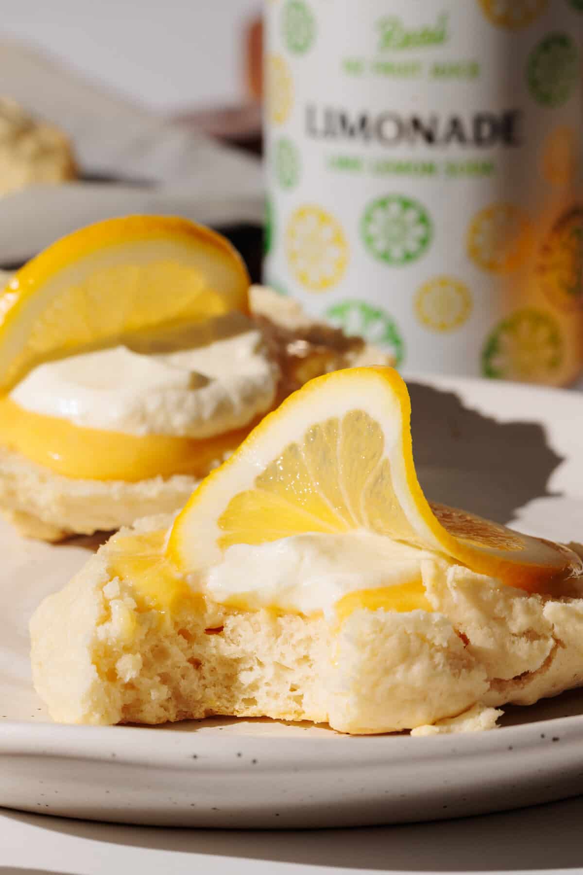 Lemonade scone with lemon curd and cream on a white plate.