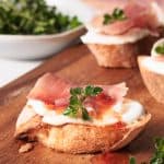 Cottage cheese crostini on wooden board.