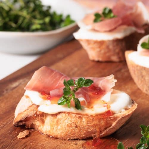 Cottage cheese crostini on wooden board.