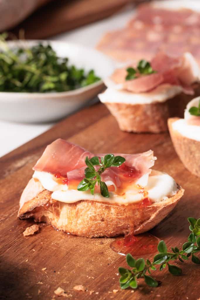 Cottage cheese crostini on wooden board.